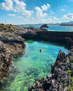 a person swimming in a swimming pool in a body of water at Apartamento en Isla Playa in Isla