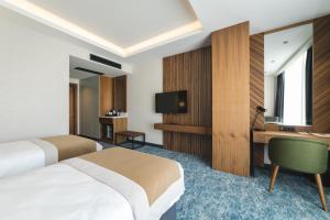 Pokój hotelowy z 2 łóżkami i biurkiem w obiekcie Bristol Hotel Podgorica w mieście Podgorica