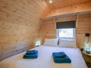 a bedroom with a bed in a wooden room at Creyr Glas Pod -uk41796 in Hirnant