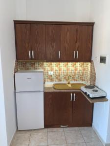una cucina con frigorifero bianco e lavandino di Vila Elite a Ksamil