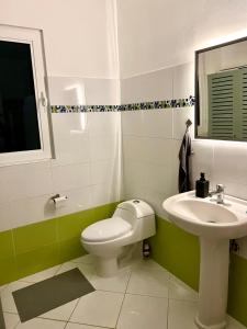 ein Badezimmer mit einem weißen WC und einem Waschbecken in der Unterkunft Piece of Paradise in Las Terrenas