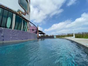 una piscina al lado de un edificio en Mermaid Hill Villa, en Magong