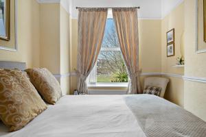 1 dormitorio con cama y ventana en Melba House, en Torquay