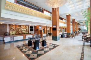 a lobby of a hotel with tables and chairs at Novotel Solo in Solo