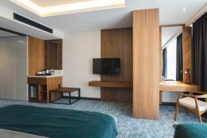 a hotel room with a bed and a flat screen tv at Bristol Hotel Podgorica in Podgorica
