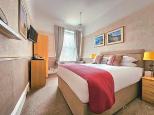 a bedroom with a large bed with a red blanket at Melba House in Torquay