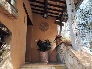 un portico di una casa con due piante in vaso di Agriturismo San Rocco Verucchio a Verucchio