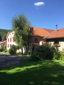 a house with a tree in front of a yard at Le Chant des Oiseaux in Vauquois