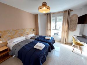 sypialnia z 2 łóżkami i biurkiem w obiekcie Habitaciones Barra89 w Walencji