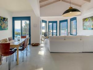 een woonkamer met een witte bank en een tafel en stoelen bij Villa Saphora Sea Front Villa in Évyiros