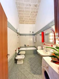 uma casa de banho com 2 WC, 2 lavatórios e uma banheira em Le 3 volte/ Antica dimora em Spongano