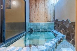 a swimming pool with a rock wall and a pool at Ichinoyu Shinkan in Hakone