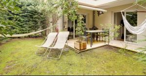 een patio met een hangmat en een tafel en stoelen bij Appartement de Standing Aux Portes de Paris in Nogent-sur-Marne