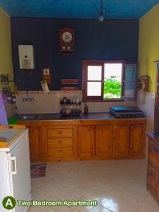 a kitchen with wooden cabinets and a window at dar zaiouane in Berga