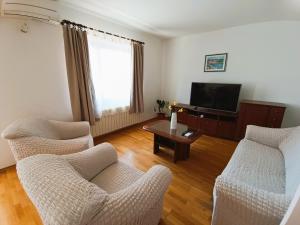 a living room with two chairs and a television at Apartment Katarina in Split