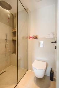 a bathroom with a toilet and a glass shower at Family Resort Urania in Baška Voda