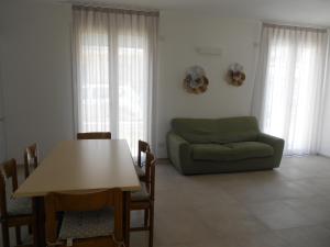 uma sala de estar com uma mesa e um sofá em Villa Glicine em Rimini