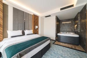 a hotel room with a bed and a bath tub at Bristol Hotel Podgorica in Podgorica
