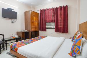 a bedroom with a bed and a tv in it at FabHotel De Gold in New Delhi