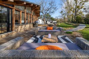 - une terrasse avec deux canapés et des oreillers orange dans l'établissement Villa du Douanier Nature d'Exception Proche Centre Ville et Vue sur le Golfe du Morbihan, à Vannes