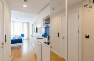 a white room with a kitchen and a living room at Orbi City Top Floor Aparthotel in Batumi +3 photos