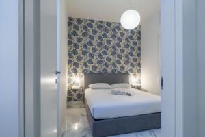 a bedroom with a large white bed and a wall at Easylife - Appartamento elegante moderno e accogliente - la tua oasi in città in Milan