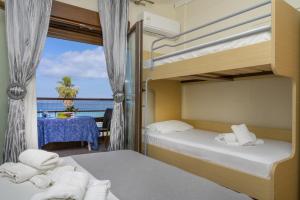 two bunk beds in a room with a view of the ocean at Xerxis Studios in Nea Roda