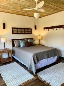a bedroom with a bed with a wooden ceiling at Chalés Cores da Mata in Tiradentes