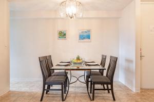 a dining room with a black table and chairs at Mountain View Oasis, Steps from Beach with Parking! in Honolulu