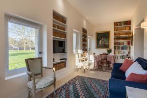 a living room with a blue couch and a window at Le Presbytère - demeure d'exception historique in Biéville-en-Auge