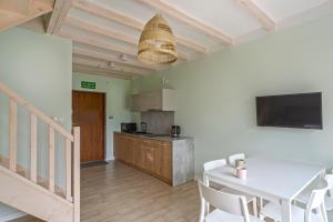 a kitchen with a table and chairs and a television at Apartamenty Nadmorska Osada in Łeba