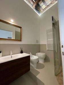 a bathroom with a sink and a toilet and a mirror at Fontana Luxury Home in Rome