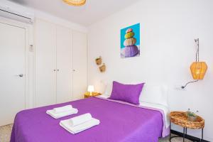 a purple bed with two towels on top of it at Empuriabrava Apartaments No 5 in Empuriabrava