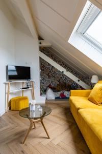 a living room with a yellow couch and a table at Appart Cosy Privé Avec parking gratuit aux portes de Strasbourg in Hoenheim