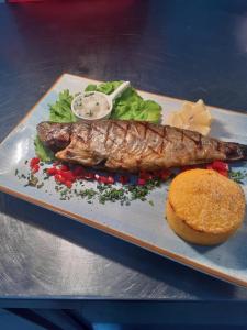 um prato de comida com um peixe e um hambúrguer em Hotel Club Bucovina Resort & Spa em Gura Humorului