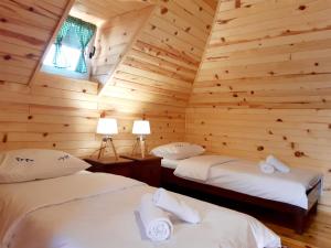 1 dormitorio con 2 camas en una cabaña de madera en El Paso City, Zlatibor - Wooden Cottages Unique, Treehouse, Wild West Rooms, accommodation 1-6 people en Zlatibor