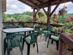 um pátio com uma mesa, cadeiras e flores em Pokoje u Izy Stare Kiejkuty em Szczytno