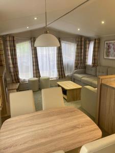 a living room with a table and chairs and a couch at 173A Woodland Way in Porthmadog