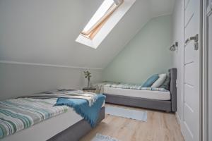 a white room with two beds and a window at Apartamenty Nadmorska Osada in Łeba +19 photos
