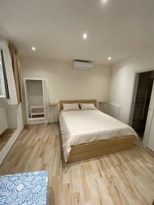 Schlafzimmer mit einem Bett und Holzboden in der Unterkunft DIMORA CAVALLERIZZA in Bari