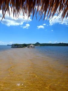 a view of the ocean from a straw hut at Portobello Hotel Orla in Santarém