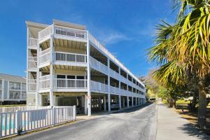 a white building with white balconies on a street at Hillside 304 in Myrtle Beach