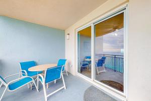a room with a table and chairs and a balcony at Sterling Breeze 1705 in Panama City Beach