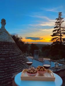 a table with two glasses of wine and a bowl of food at Suggestivo Trullo in valle d'itria in Ceglie Messapica