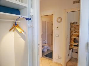 La salle de bains est pourvue de toilettes et d'un placard. dans l'établissement Beach Kite 8 posti letto - Terrazzo e parcheggio, à Grado-Pineta