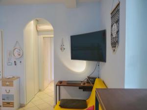 - un salon avec un bureau et une télévision murale dans l'établissement Beach Kite 8 posti letto - Terrazzo e parcheggio, à Grado-Pineta