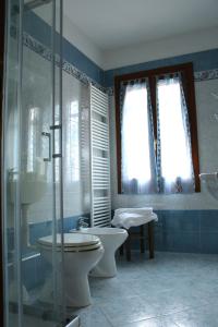 y baño con aseo, lavabo y ducha. en Locanda della Pescheria en Comacchio