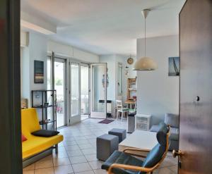 - un salon avec un canapé jaune et une table dans l'établissement Beach Kite 8 posti letto - Terrazzo e parcheggio, à Grado-Pineta