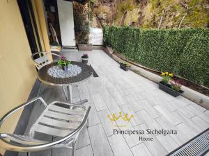 a patio with a table and chairs and flowers at Principessa Sichelgaita House in Salerno