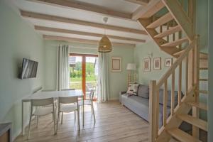 a dining room and living room with a table and stairs at Apartamenty Nadmorska Osada in Łeba